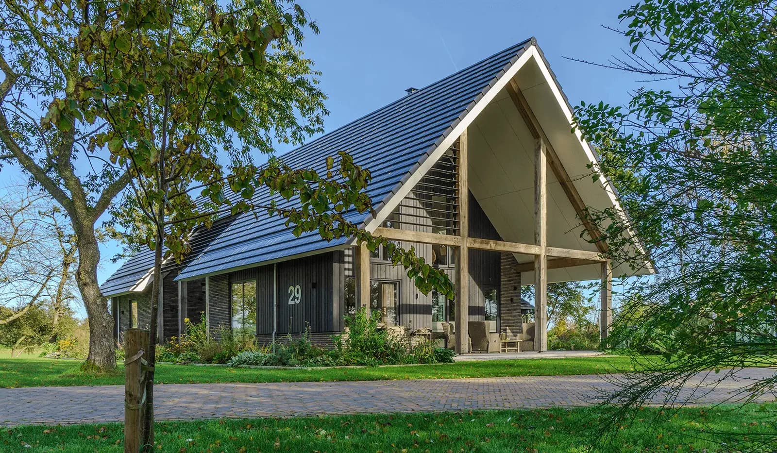 Moderne schuurwoning in Steggerda met open geveltop, houten spanten, donker metselwerk en royale glaspartijen — ontworpen door MArchitecten.