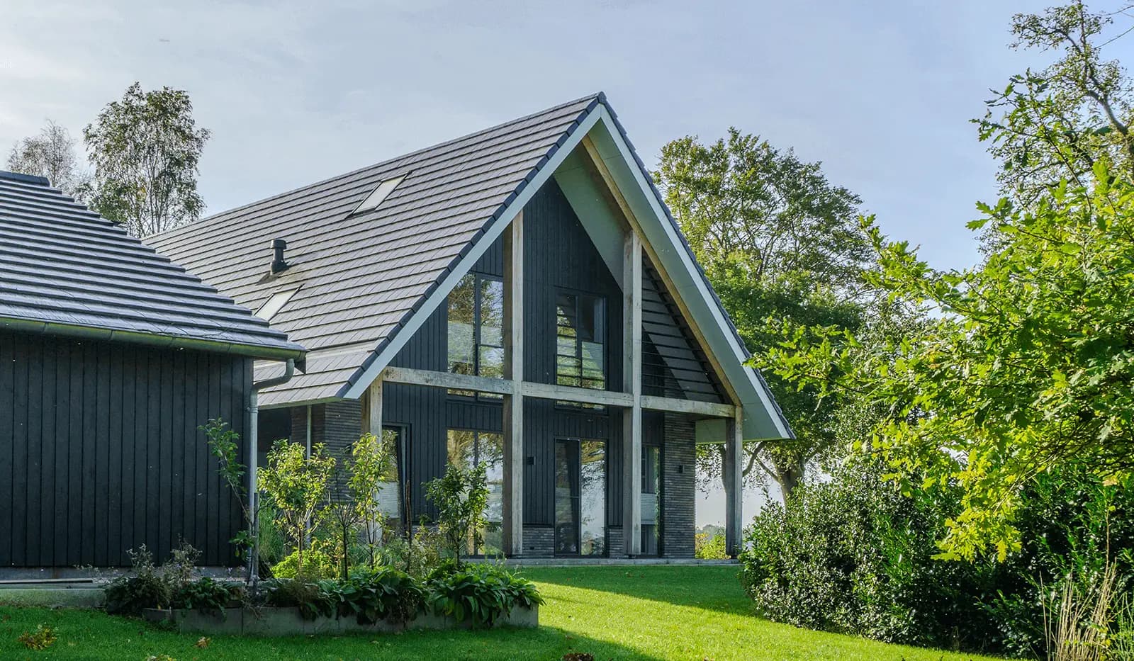 Moderne schuurwoning in Steggerda met open geveltop, houten spanten, donker metselwerk en royale glaspartijen — ontworpen door MArchitecten.