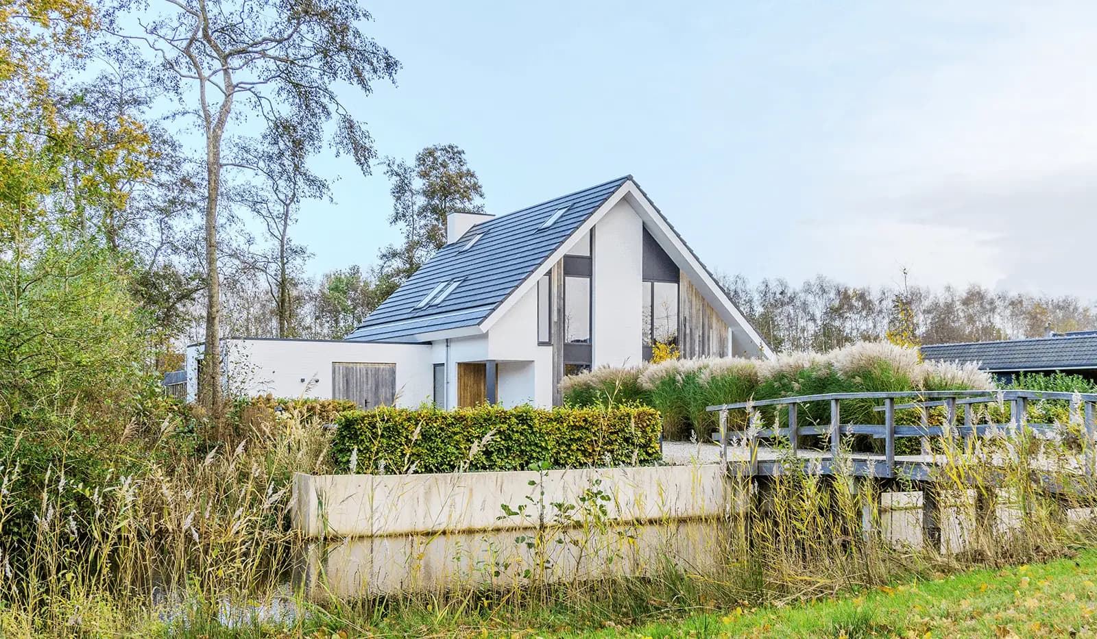 Modern minimalistisch woonhuis in Oranjewoud met verticale gevelelementen, keim-afwerking en grote glaspartijen.