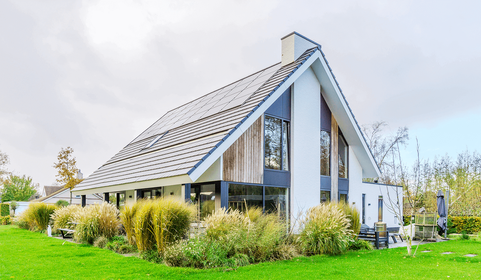 Modern minimalistisch woonhuis in Oranjewoud met verticale gevelelementen, keim-afwerking en grote glaspartijen.