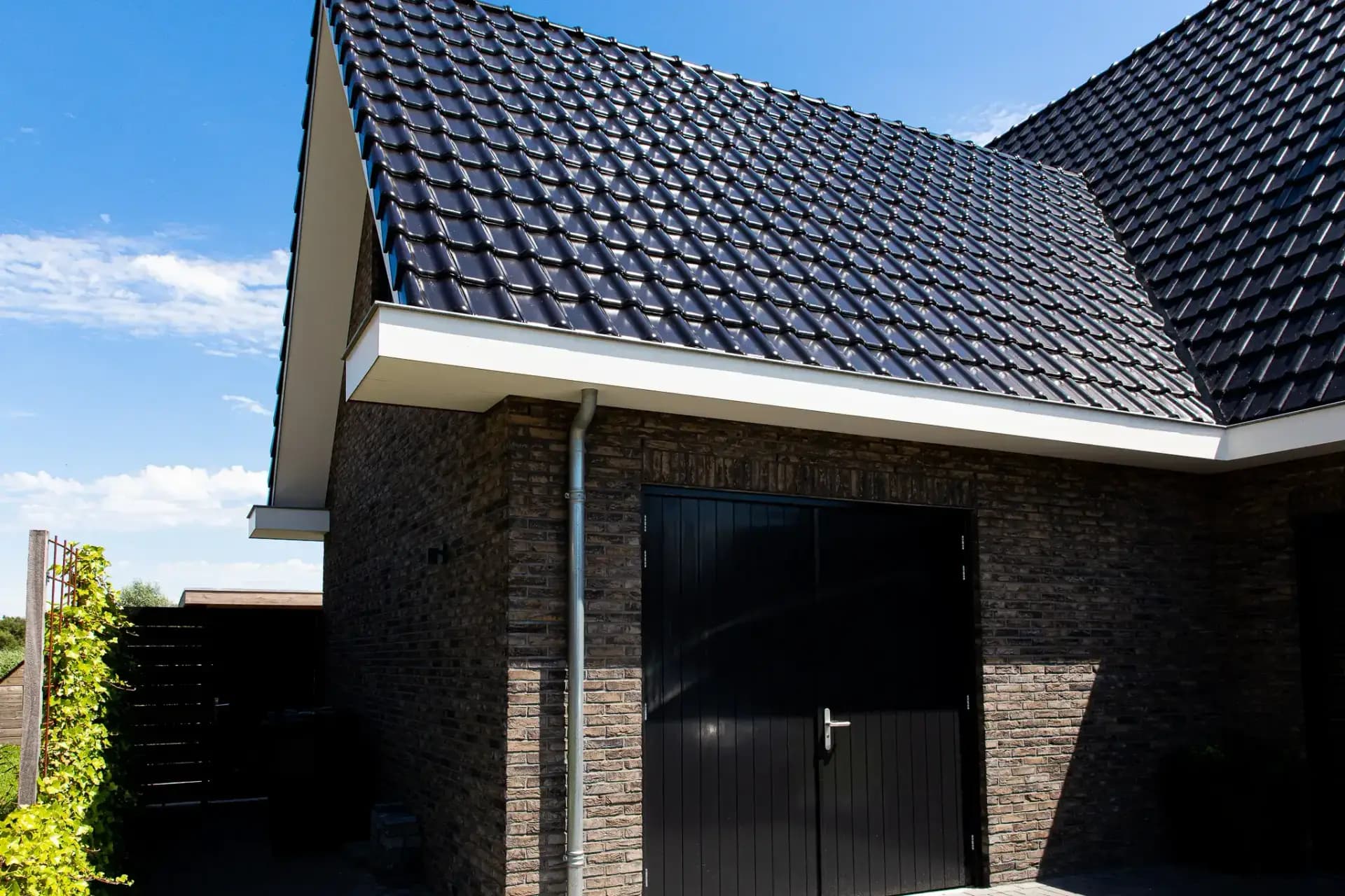 Traditioneel woonhuis Argusvlinder in Wolvega met klassieke gevel, zijbeuk en moderne kleurstelling — grote glaspartijen openen naar uitzicht op het water.