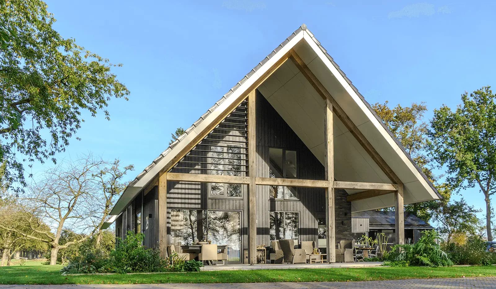 Moderne schuurwoning in Steggerda met open geveltop, houten spanten, donker metselwerk en royale glaspartijen — ontworpen door MArchitecten.