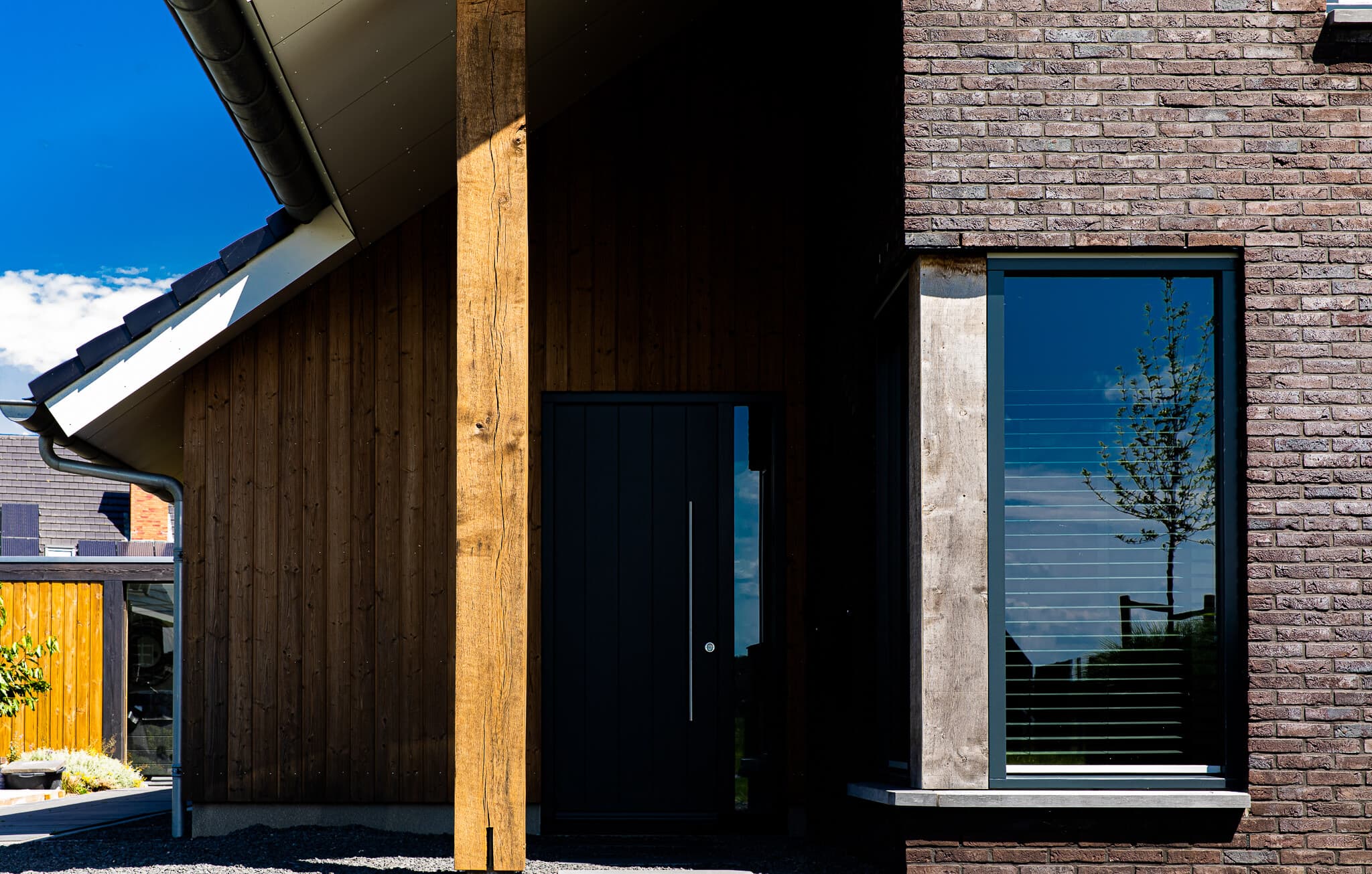 Vrijstaand modern woonhuis aan het Heideblauwtje in Wolvega (Lindewijk) met baksteen, houten accenten, leigrijze kozijnen en licht boeideel.