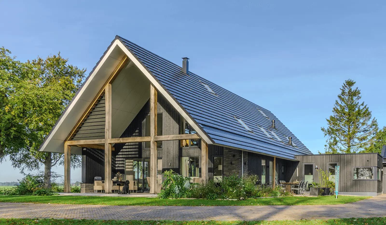 Moderne schuurwoning in Steggerda met open geveltop, houten spanten, donker metselwerk en royale glaspartijen — ontworpen door MArchitecten.